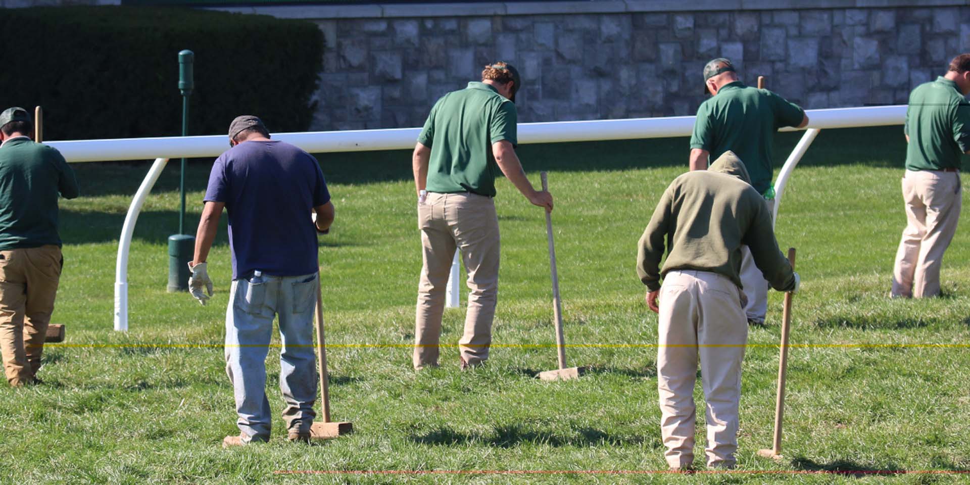 An action shot of Hoofstrike team members tamping down turf divots.